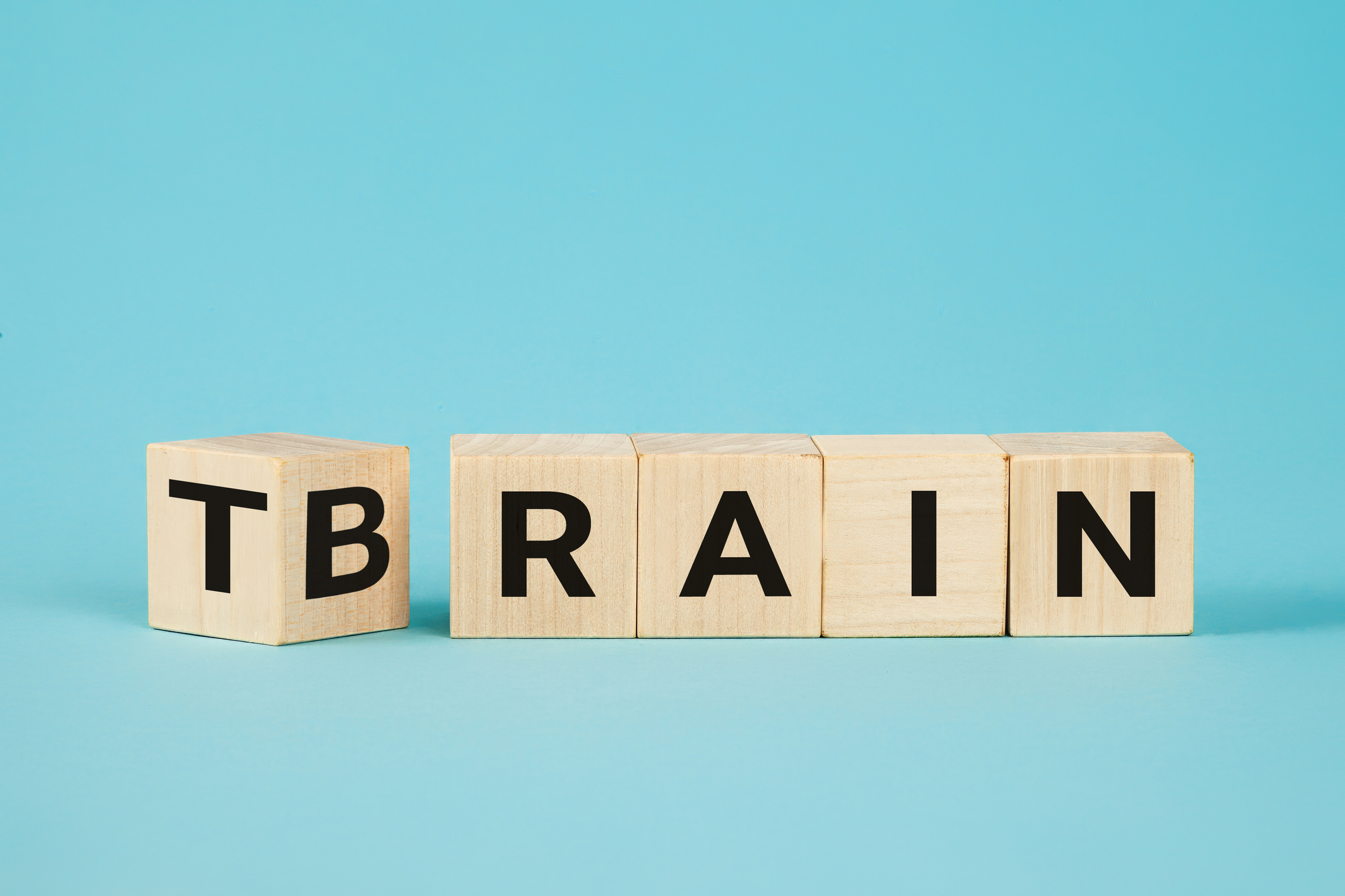 Train Your Brain. Turns a cube and changes the word 'train' to 'brain' on wooden cubes. Dice form the words train and brain. Business and train your brain concept